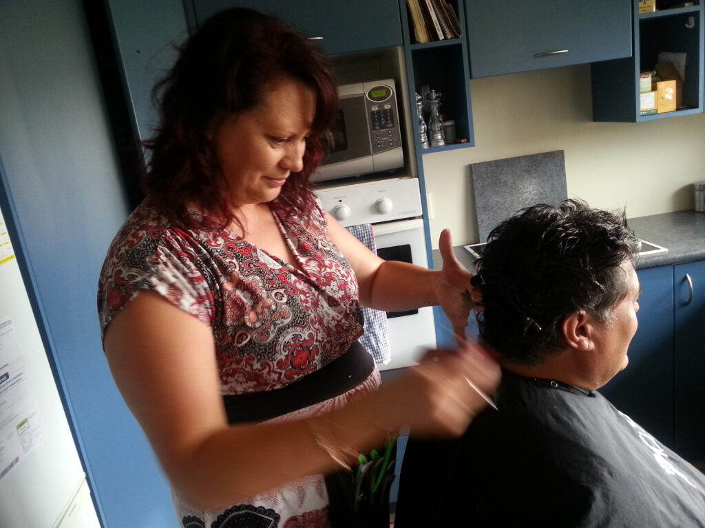woman hairdresser combing hair of man